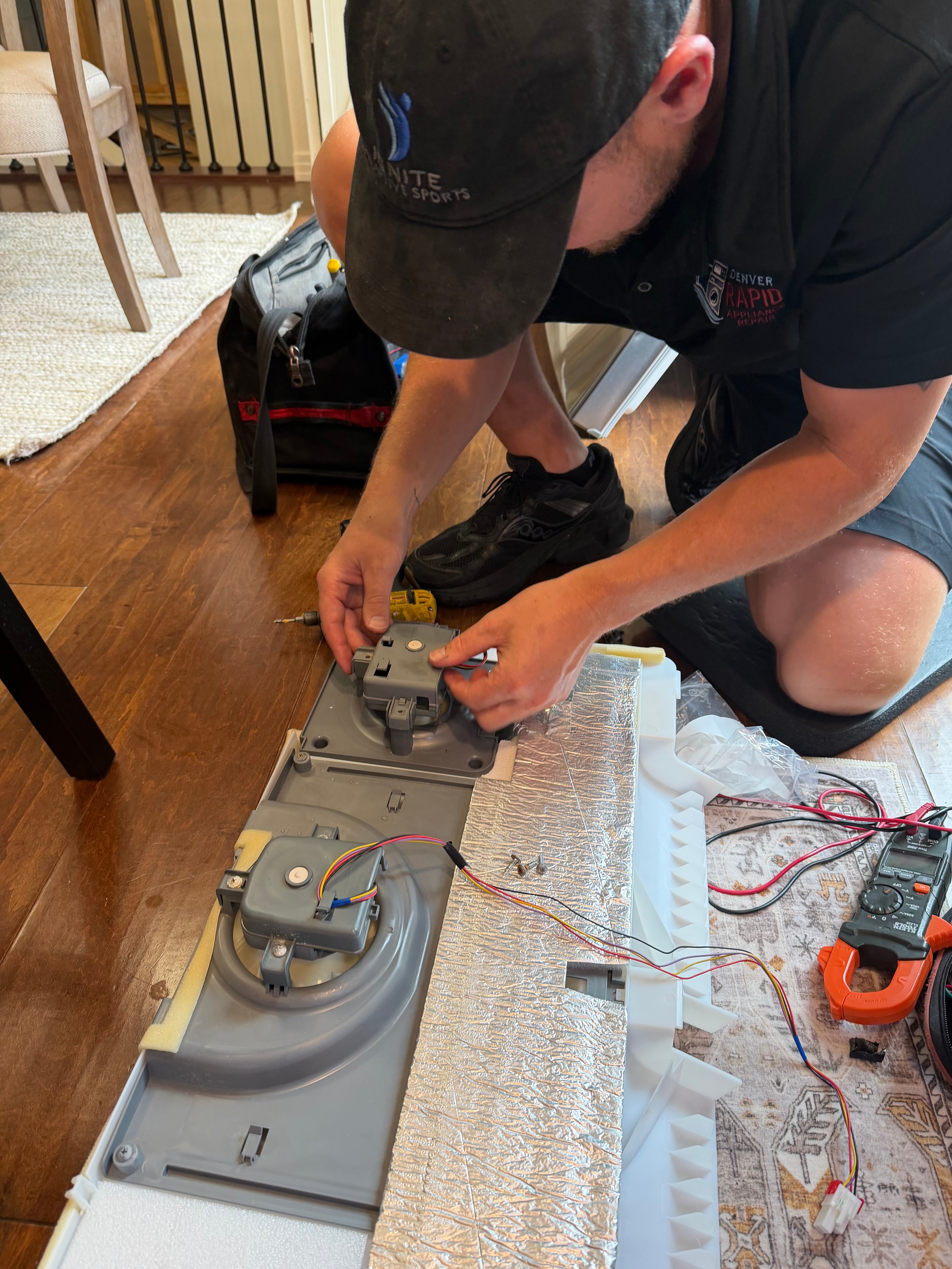 Technician installing new LG evaporator fan motor EAU65058313 into ice room housing