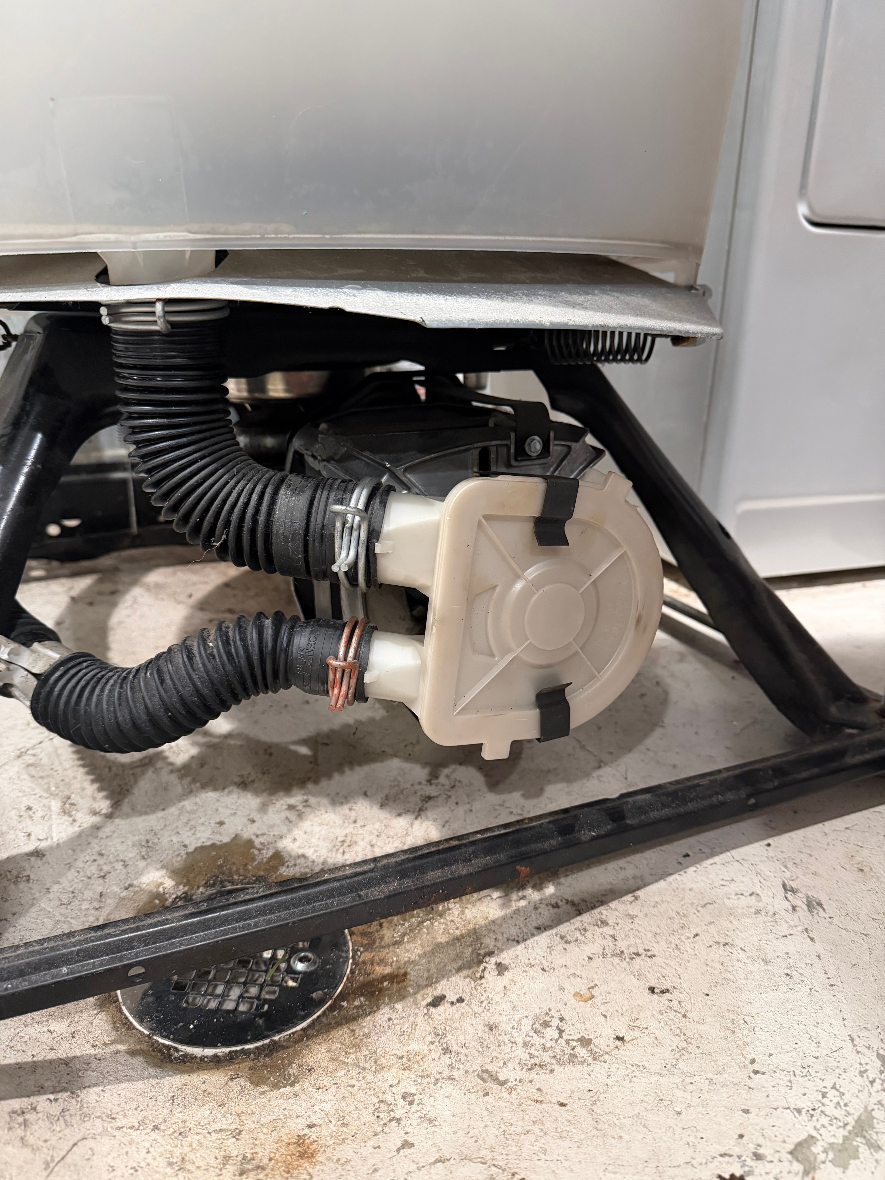 Replacement WP3363394 drain pump installed on Whirlpool direct-drive washer